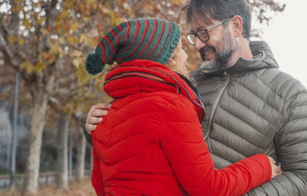 Mature people dating in outdoor leisure activity.  woman hug man with love. Relationship and romantic place. Autumn outdoors nature background. Winter clothes, travel lifestyle. Romance. Bonding.