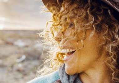 Aşırı mutlu yetişkin bir kadının yan görünüş portresi gülümseyen ve eğlenen, açık havada eğlenen arka planda doğa ile tek başına eğlenen. Gezgin ve turist. İnsanlar hayattan zevk alıyor.