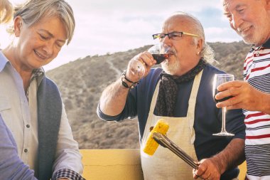 Yaşlılardan oluşan mutlu, neşeli bir grup birlikte kadeh kaldırır ve dostça yemek yeriz.