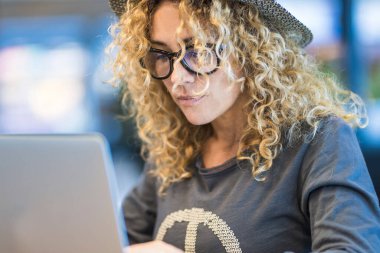 Dizüstü bilgisayar ve gözlüklerle çalışan modern bir kadın. Moda seyahat eden iş için internet bağlantısı olan kadınlar. Uzak işçi masaüstü ofis yaşam tarzı kavramı