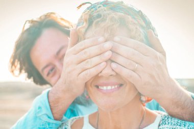 Açık hava aktivitelerinde mutlu turistler. Adam sürpriz yapmak için bir kadına gözlerini kapadı. Aşk ve dostluk, yetişkin çift. İnsanlar dışarıda birlikte eğleniyor. Turistlerin portresi