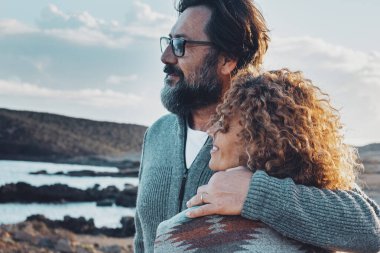 Romantik insanlar erkek ve kadın kucaklaşıyorlar ve güzel manzara manzarasına hayran kalıyorlar. Arka planda rüzgar türbinleri olan gezgin çift, açık havada romantik aktivitelerin tadını çıkarıyor. Açık havada aşık bir çift.