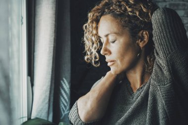 Sırt ağrısı ve kollarını açmak için boynuna dokunan olgun bir kadın. Sağlıklı ve vücutsal durum kavramına göre insanlar sırtına ağrı için masaj yapıyorlar ve rahatlamak için gözlerini kapatıyorlar. Kötü duruş kavramı