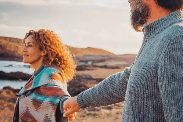 Mutlu çift el ele tutuşup birlikte yürüyor ve manzaralı bir yeri keşfediyor. Seyahat ve romantik ilişki yaşam tarzı, kırsalda tatil yapan bir turist. Kadın ve erkek açık havada aşk yaşıyor.