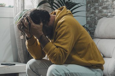 Adam evde yalnız başına çaresizlik ve hüsranla başını tutuyor. Kapalı alandaki stresli insanlar kavramı. Aşırı endişe ve çözülmesi gereken sorunlar. Kötü bir gündü. Ekonomik kriz ve iflas etmiş aile durumu