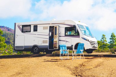 Doğadaki güzel turizm karavanı kamp alanı. Seyahat ve karavan kiralama tatili. Modern karavanın mavi gökyüzü arka planına park edilmiş Vanlife ve Gezinti Konsepti