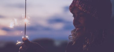 Maytap kullanan mutlu bir kadının yan görüntüsü ve dışarıda tek başına kutlama yapması. Kış mevsimi ve kadın insanlar. Noel ya da yeni yıl arifesi kutlama konsepti yaşam tarzı. Siyah portre