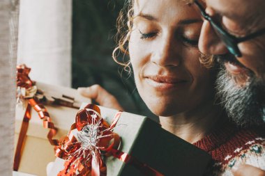 Noel tatili için evde romantik bir eğlence aktivitesi. Aşık bir erkek ve bir kadınla aşk ve ilişki aktiviteleriyle hediye alışverişi. Erkek sarılan kadın. Kapalı gözler ve şefkat. İnsanlar seviyor