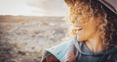 Mutluluktan havalara uçmuş, gülümseyen ve eğlenen, dışarıda eğlenen, arka planda doğayla baş başa eğlenen genç bir kadının yan görünümü. Gezgin ve turist. İnsanlar hayattan zevk alıyor.