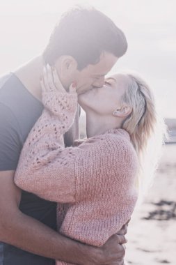 İlişkisi olan bir çift açık havada öpüşüyor. Çıkma ve birlikte tatil kavramı. Genç kız ve erkek güneşin altında romantik bir öpüşme. Yaz tatilinde plajda kucaklaşan iki kişi.