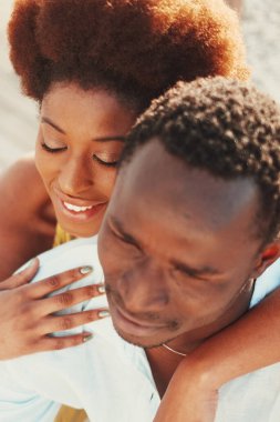 Above view of young pretty black woman and man together hugging with love and romance. Boyfriend and girlfriend in relationship. Romantic leisure activity concept. Dating. Two people in love