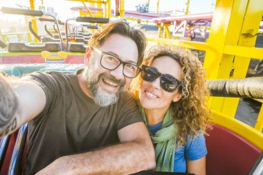 Hız trenine binen bir çift eğlendi. Güneşli bir öğleden sonra ve eğlence. Boş zaman ve neşe kavramı