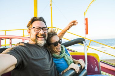 Hız trenine binen bir çift eğlendi. Güneşli bir öğleden sonra ve eğlence. Boş zaman ve neşe kavramı