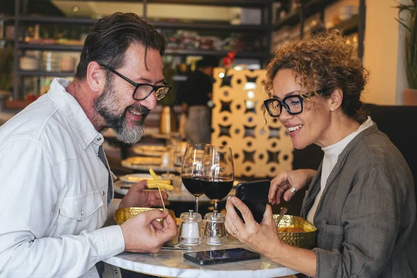 Happy Couple Smiling Talking Restaurant Looking Cell Phone Married Couple — Stock Photo, Image