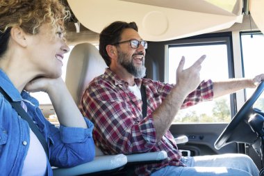 Karavan kullanan adam, karısı ile araba sürerken gülümsüyor. Seyahat, tatil ve birlikte yaşam kavramı