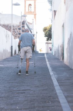 Dışarıda protez bacaklı yaşlı bir adam.