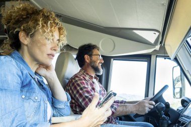 Karavan kullanan adam, karısı ile araba sürerken gülümsüyor. Seyahat, tatil ve birlikte yaşam kavramı