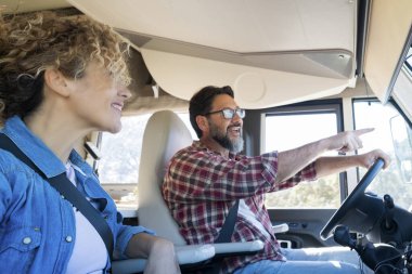 Karavan kullanan adam, karısı ile araba sürerken gülümsüyor. Seyahat, tatil ve birlikte yaşam kavramı