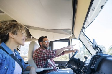 Karavan kullanan adam, karısı ile araba sürerken gülümsüyor. Seyahat, tatil ve birlikte yaşam kavramı