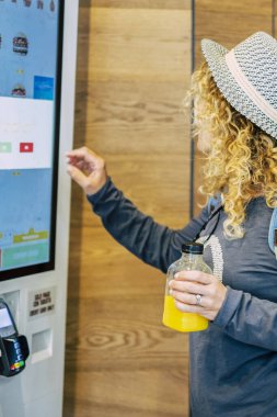 Kadınlar fast food restoranında yemek siparişi veriyor - self servis paneli teknolojisi ve seyahat yaşam tarzı olan insanlar hamburger yiyor.