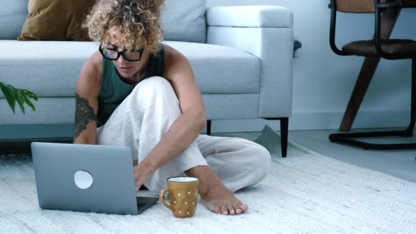 現代の屋内レジャー活動だけでも 家の床に座っている ラップトップコンピューターを使っている女性です スマートな作業とWebコンセプトの人々のライフスタイルを検索します トレンドの女性の使用ノート屋内 — ストック動画