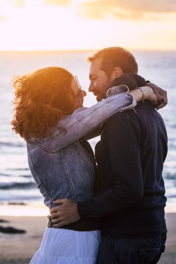 Açık havada öpüşen romantik, olgun bir çift. Sahilde okyanus manzaralı muhteşem bir gün batımına karşı. Dışarıda kucaklaşan bir erkekle bir kadın ilişkisi. Deniz ve gökyüzü rengi. Yaz randevusu