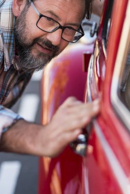 Bir adamın yeni arabasının olması yakındır. Araç sevenler konsepti. Parlak ve cilalı arabaları kontrol eden erkekler. Otomobil sahibi veya tamircisi. Ulaşım konsepti ve rüya gören yetişkin
