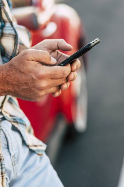El manifatura iletisinde telefon tutarak veya mobil uygulamaları kullanarak, sosyal medya uygulamaları yeni siyah smartphone cep telefonu ile kontrol, oyun oyun cep telefonu, erkek müşteri ve gadget yakın bakış üzerinde çalışıyor adam