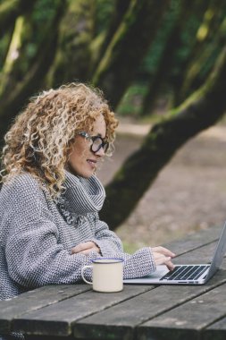 Dijital göçebe yaşam tarzı konsepti. Genç kadın tahta dizüstü bilgisayar kullanıyor.