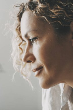 Emekli bir kadının yan portresi. Anıları ve sağlıksız akıl hastalıklarını hatırlamak. Önüne bakan sakin bir kadın. Evlerinde düşünceli yüzleri olan insanlar. Evde düşünen ve gülümseyen bir kadın