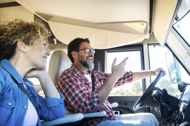 Karavan kullanan adam, karısı ile araba sürerken gülümsüyor. Seyahat, tatil ve birlikte yaşam kavramı