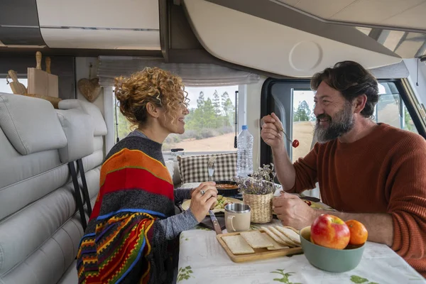 Bir karavanda masada oturup öğle yemeği yiyen ve dinlenen iki yolcu. Sakallı adam ve sarışın kadın yemek yerken konuşurlar. Seyahat kavramı yemek ve dinlenmek için durur.