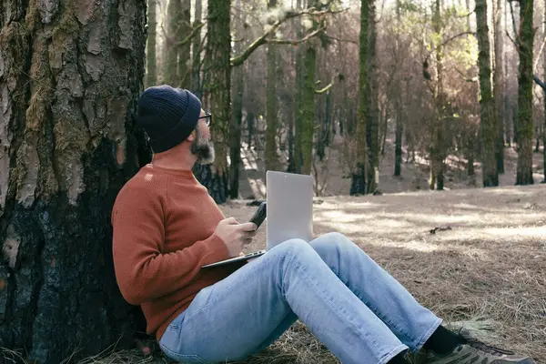 man using technology connection in nature park forest woods. Remote worker small travel business lifestyle people. Working in the nature alternative office. Small business. Travelers job life