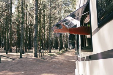  Karavan karavanının penceresinin önündeki manzaranın tadını çıkaran bir adam. Vanlife 'ın ve alternatif seyahat aracı tatilinin tadını çıkarıyor. Özgürlük için. Göçebe yaşam tarzı tam zamanlı çalışanlar. Ücretsiz park aracı