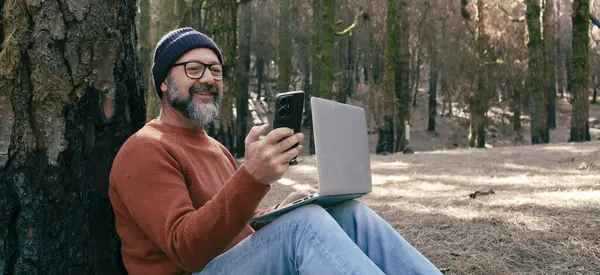 man using technology connection in nature park forest woods. Remote worker small travel business lifestyle people. Working in the nature alternative office. Small business. Travelers job life