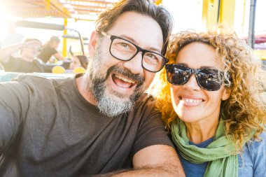 Tema parkında gülümseyen mutlu bir çift lunaparkta gezinti yapıyor. Eğlence parkında 50 yaşındaki mutlu çiftin yakın çekimi.. 