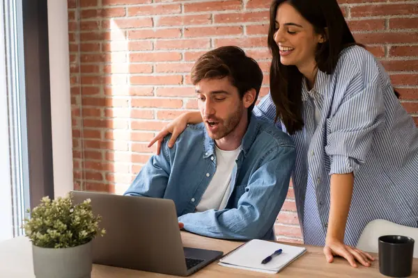  Evdeki çift dizüstü bilgisayarda internete bakıp gülümsüyor ve mutluydu. Genç bir adam ve kadın bilgisayar kullanıyor ve eğleniyorlar. Tatil planlama insanlar tatil sezonu