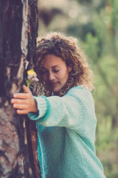 Nature love and environment. Sustainable lifestyle people. woman bonding a big trunk tree in the forest woods. Concept of natural protection. Green woods background. Stop deforestation outdoors