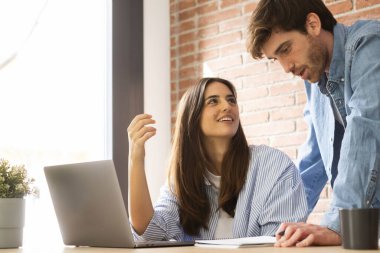 Genç milenyum çifti bir dizüstü bilgisayar ve internet işiyle birlikte çalışıyor.. 