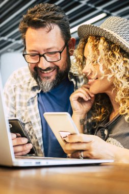 couple working together in coworking space with mobile phones and laptop computer. Modern online job lifestyle people. Happy man and woman travel. Social media business activity web