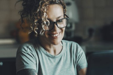  lady working at home with laptop and smiling. Woman enjoying online connection and browsing web. Searching on internet pages. Indoor technology people leisure online activity concept female
