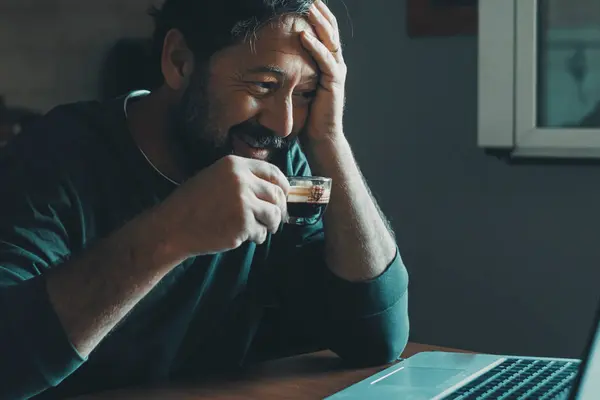 Alene Mann Hjemme Bruker Laptop Som Smiler Drikker Espressokaffe Kjøkkenet – stockfoto