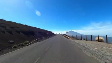 Dağ manzaralı yol boyunca araba sürüyorum. Güzel, boş bir yoldan geçen bir kameranın görüntüsü. Ulaşım ve sürücü bakış açısı kavramı. Dağ yolculuğu. Arka planda mavi gökyüzü