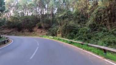 Dağ manzaralı yol boyunca araba sürüyorum. Güzel, boş bir yoldan geçen bir kameranın görüntüsü. Ulaşım ve sürücü bakış açısı kavramı. Dağ yolculuğu. Arka planda mavi gökyüzü