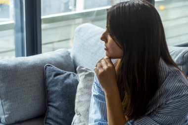 Depresyondaki genç bir kadın evdeki oturma odasında oturmuş hayal kırıklığına uğramış bir kadın mutsuz bir sorun yaşıyor.