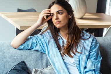 Depresyondaki genç bir kadın evdeki oturma odasında oturmuş hayal kırıklığına uğramış bir kadın mutsuz bir sorun yaşıyor.