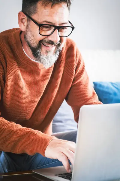 Hymyilevä Vanhempi 50S Mies Istua Rentoutua Sohvalla Olohuoneessa Selaamassa Internetiä — kuvapankkivalokuva