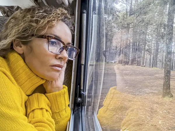 Kobieta Okularach Żółtym Swetrze Relaksuje Się Patrząc Przez Okno Pani — Zdjęcie stockowe