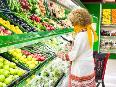 Market / süpermarketin üretim bölümünde sebze ve meyve alışverişi yapan güzel bir genç kadın (renkli görünüm))