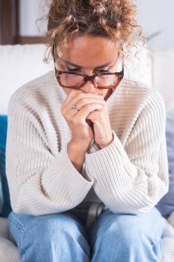 Mutsuz yetişkin bir kadın evdeki kanepede oturur ve pencereye bakar, sorun ve sorunları düşünür, depresyon ya da yalnızlık çeker, zihinsel hastalıklar, zor kararlar verir.